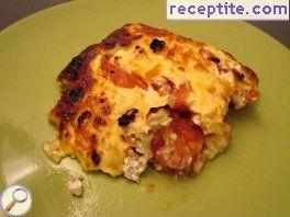 Tomatoes with eggs and feta cheese in the oven